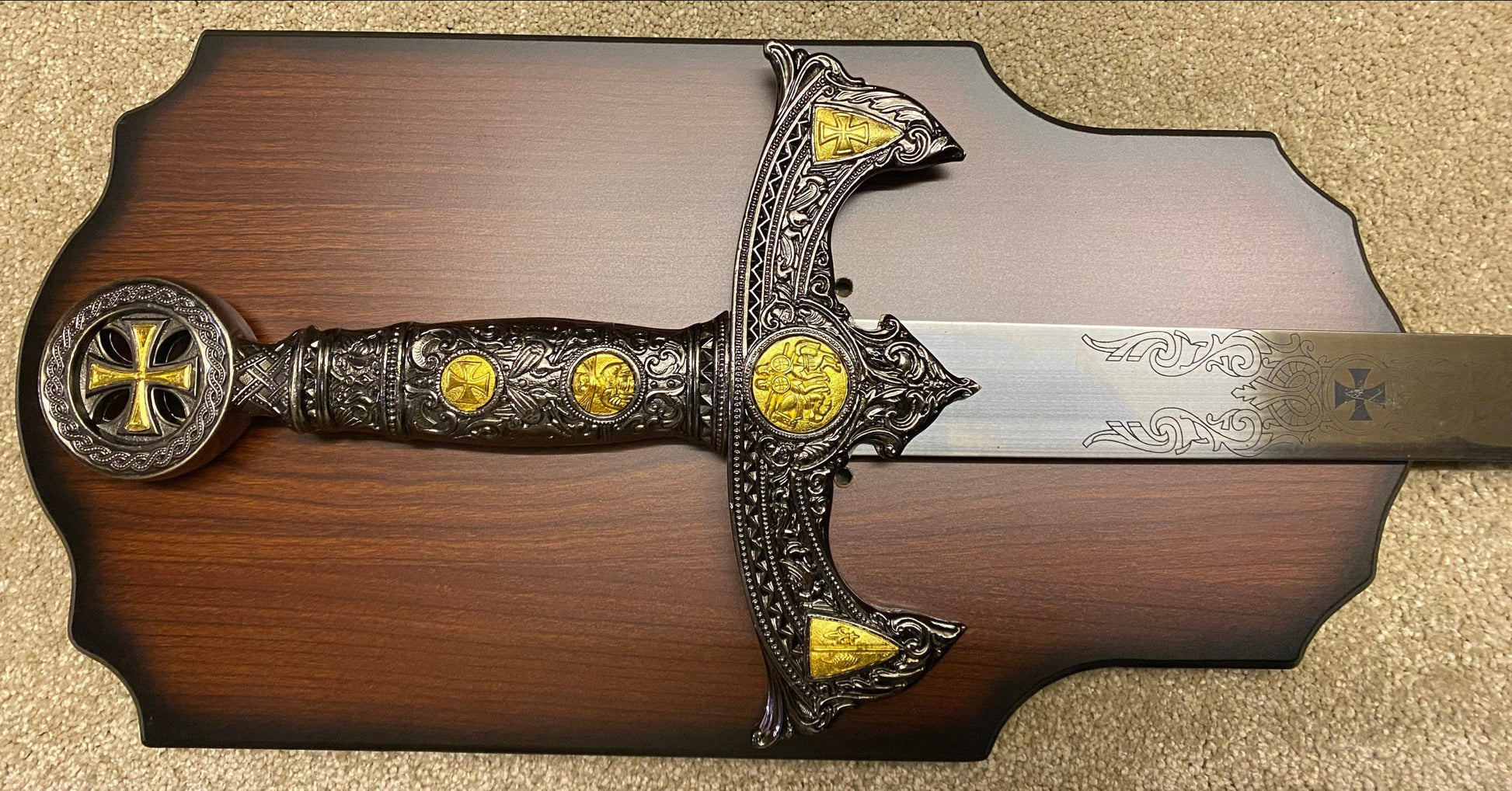 Decorative sword with gold accents on a wooden plaque