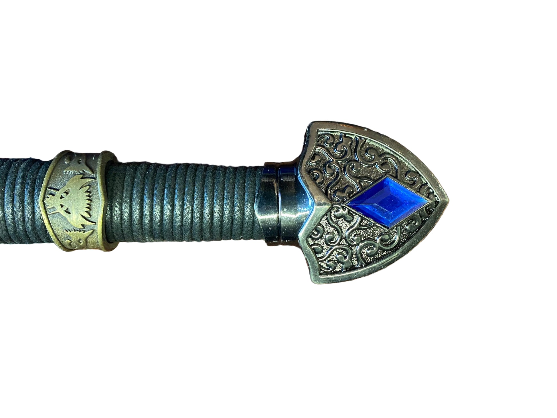 Decorative spear head with intricate designs and a blue gemstone on a white background