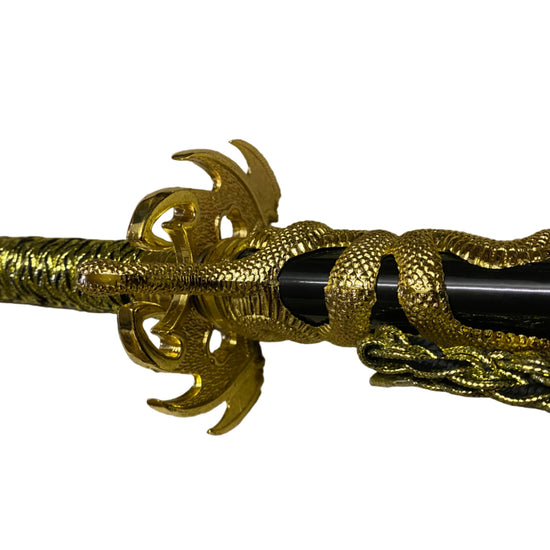 Decorative gold and black object with intricate design on a white background