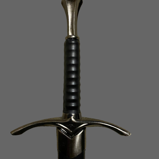 Sword with a black handle and silver blade on a gray background