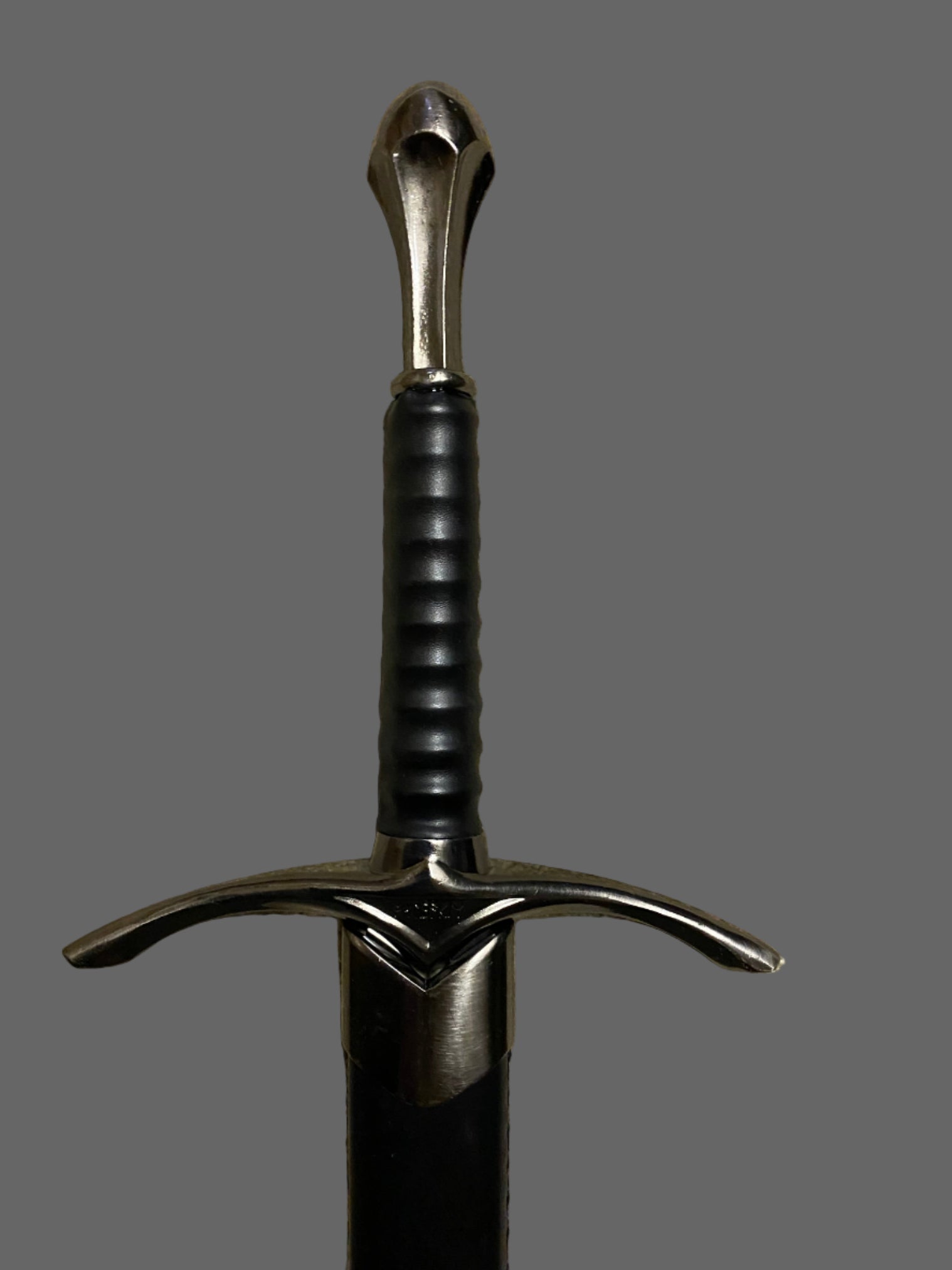 Sword with a black handle and silver blade on a gray background