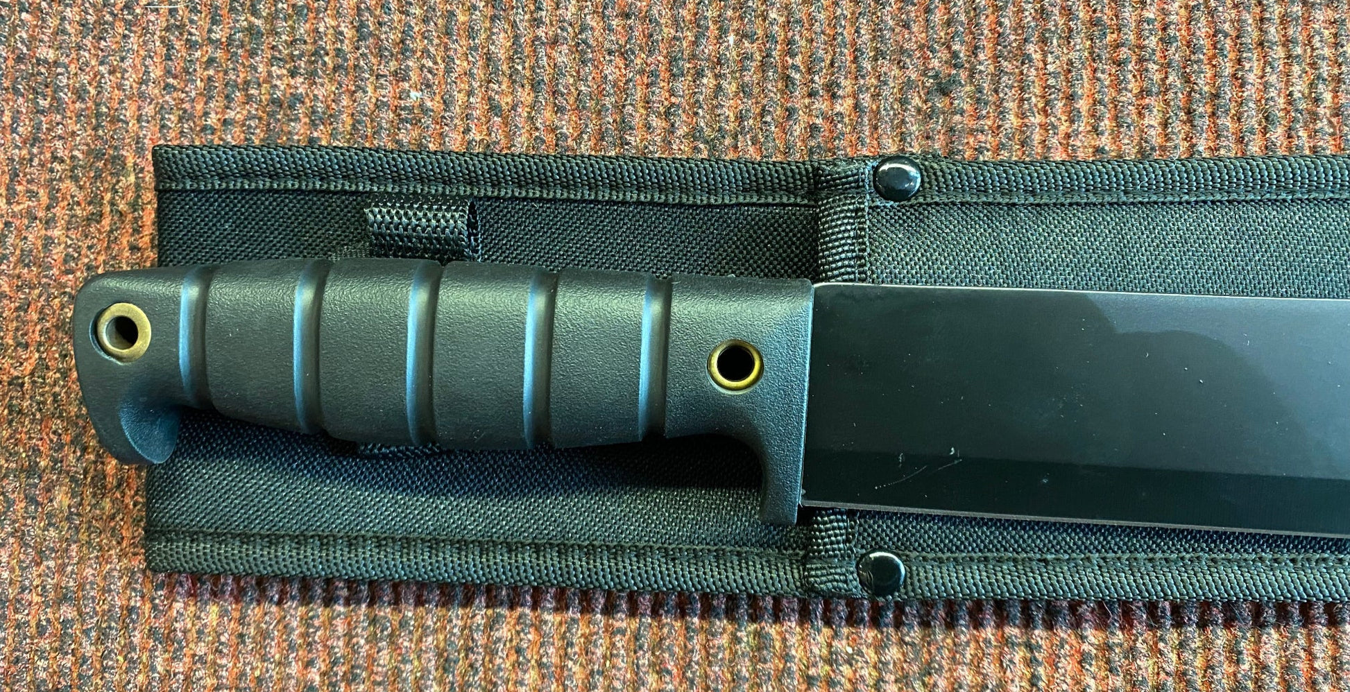 Knife with sheath on a textured surface