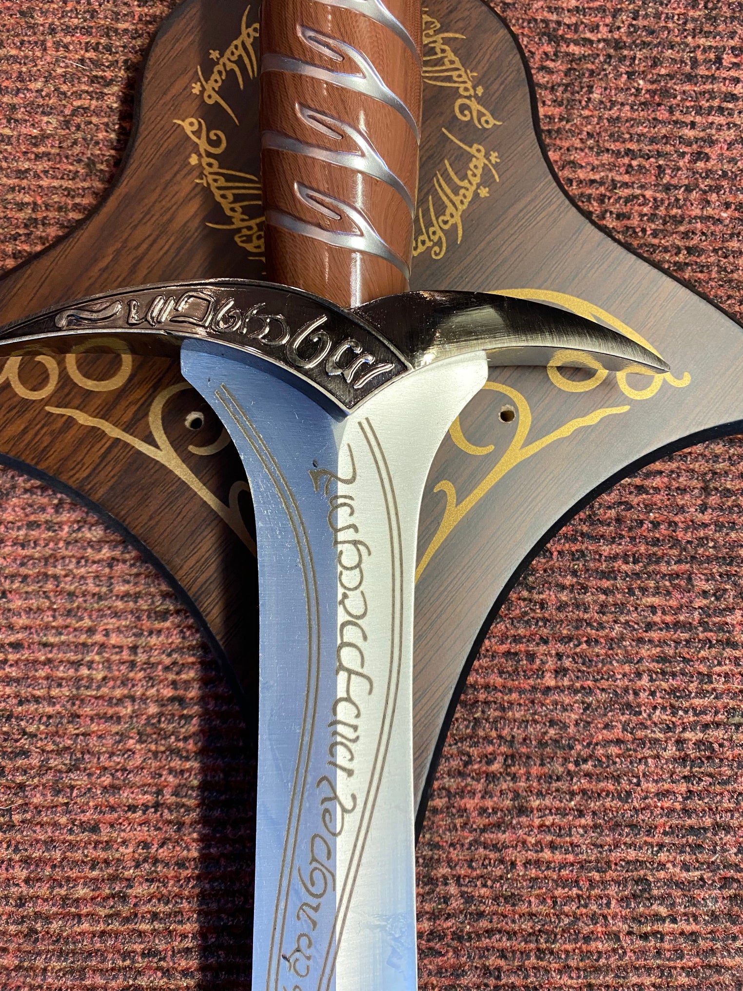 Close-up of a sword with ornate handle and blade on a textured brown background