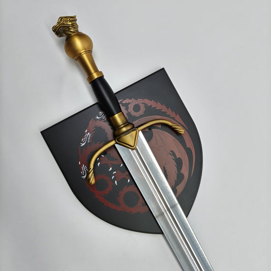 Decorative sword with gold hilt on a black plaque with red design