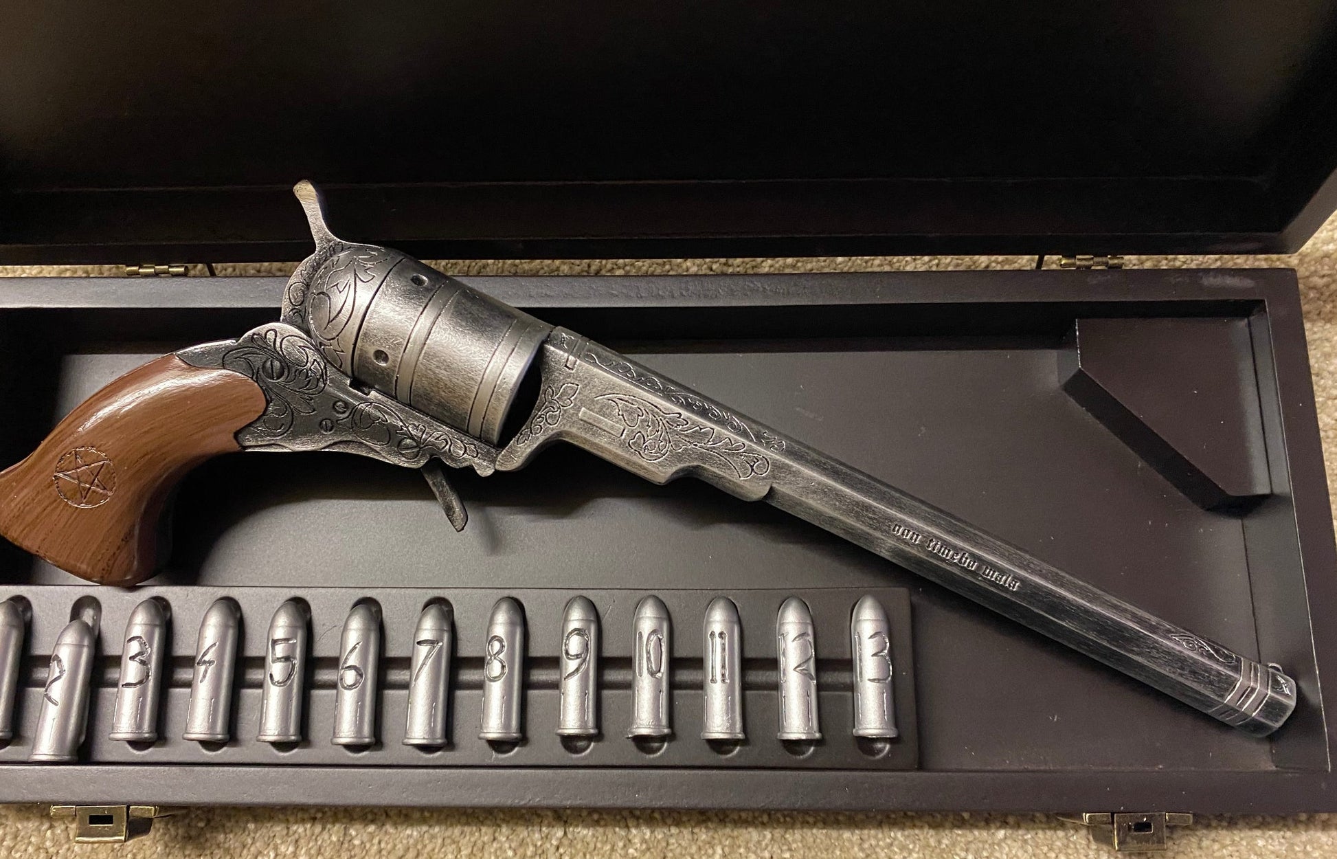 Vintage revolver and bullets in a wooden gun case.