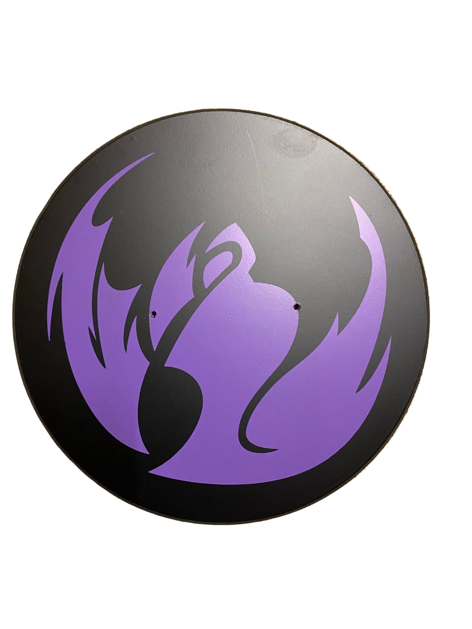 Round black object with purple flame-like design on a white background
