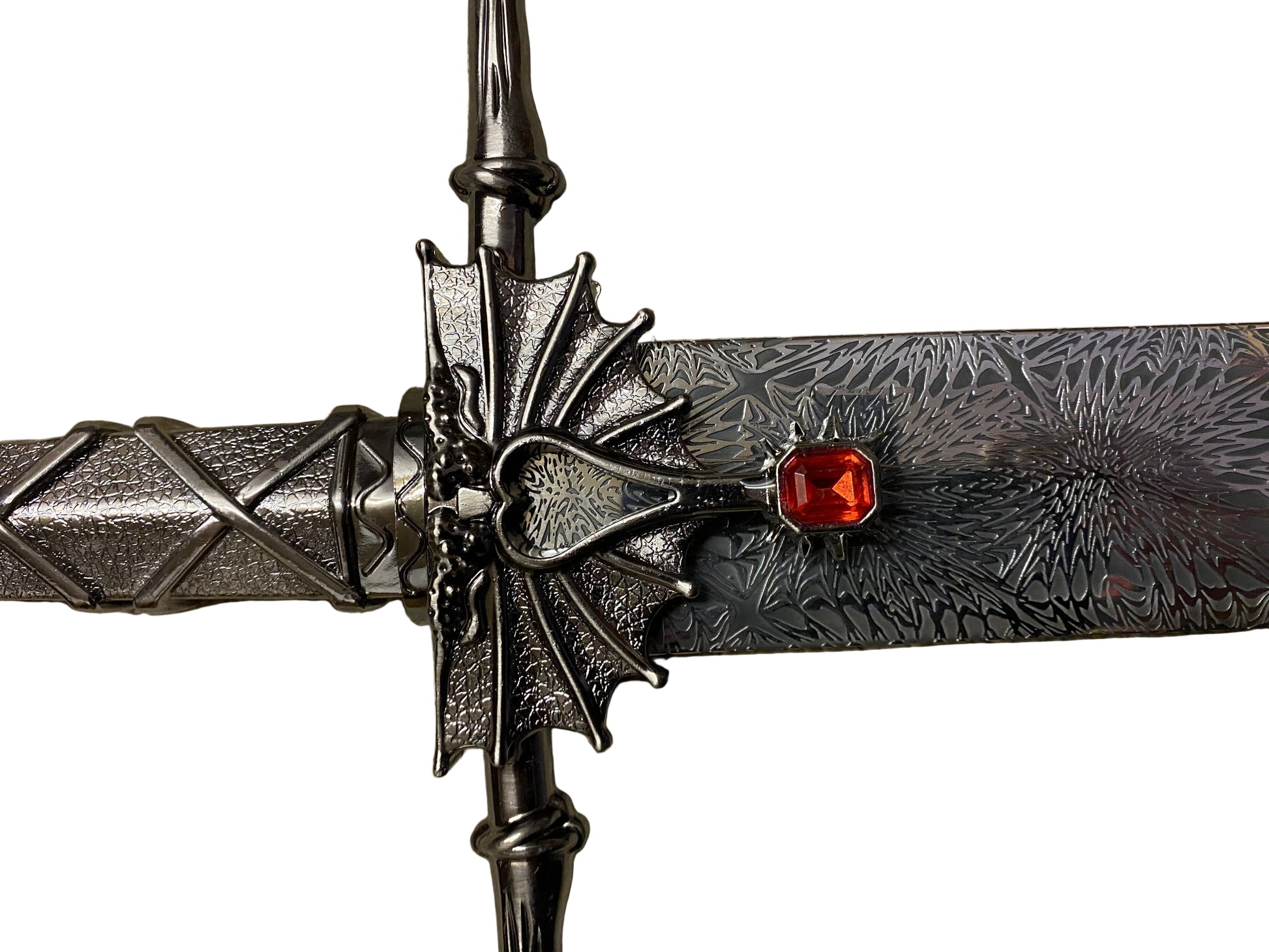 Decorative dagger with intricate design and red gemstone on a white background