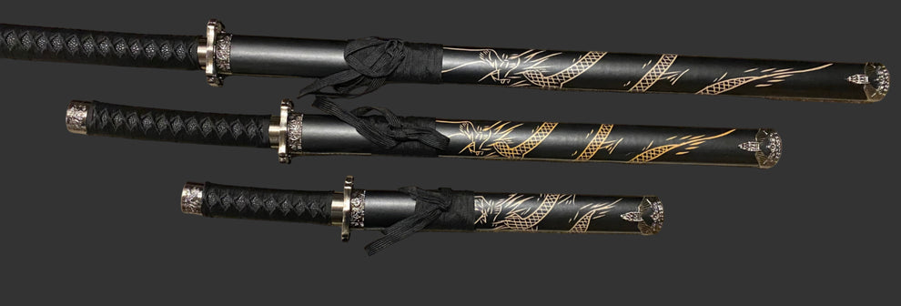 Three black and gold decorative swords on a dark background