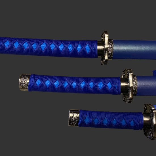 Three blue-handled samurai swords with decorative hilts on a gray background