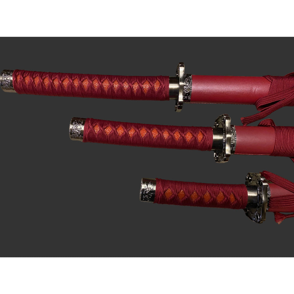 Three red swords with silver hilts on a gray background