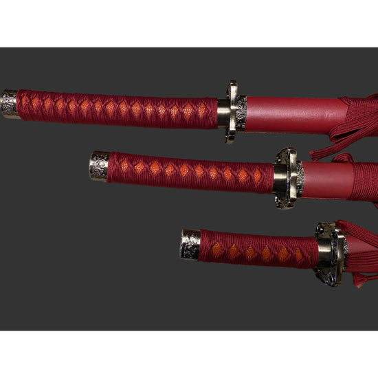 Three red swords with silver hilts on a gray background