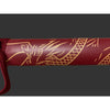 Maroon cylindrical object with gold leaf patterns on a dark background