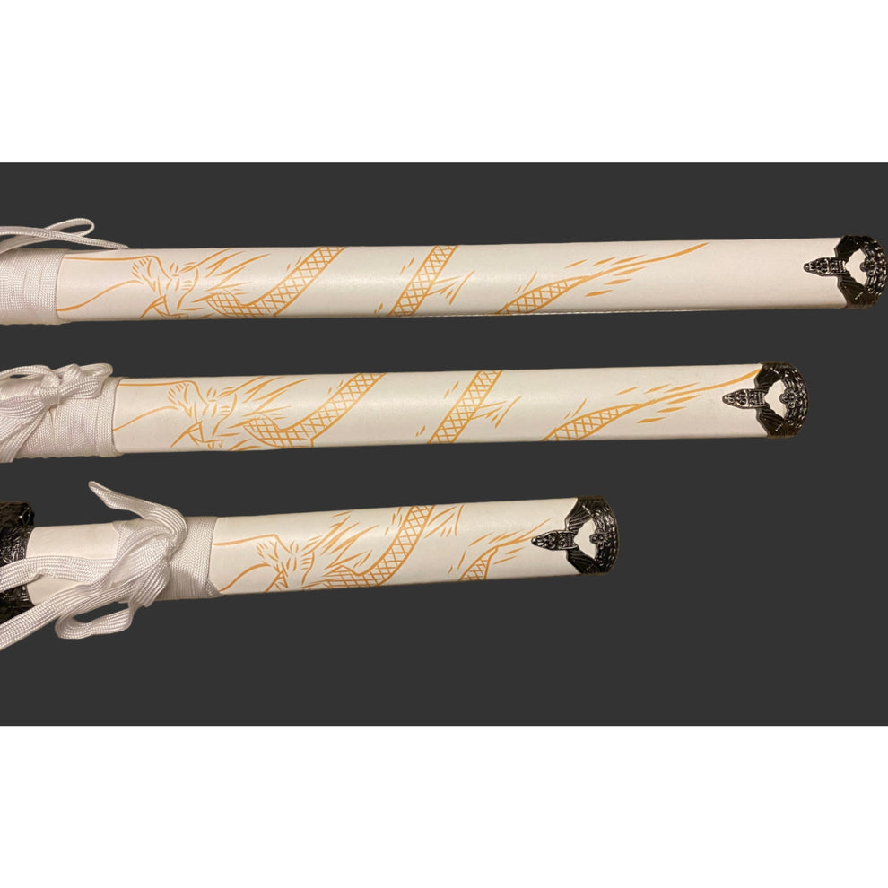 Three decorative sword sheaths with intricate gold patterns on a dark background