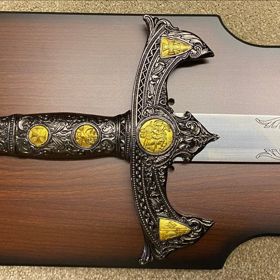 Decorative sword with gold accents on a wooden plaque