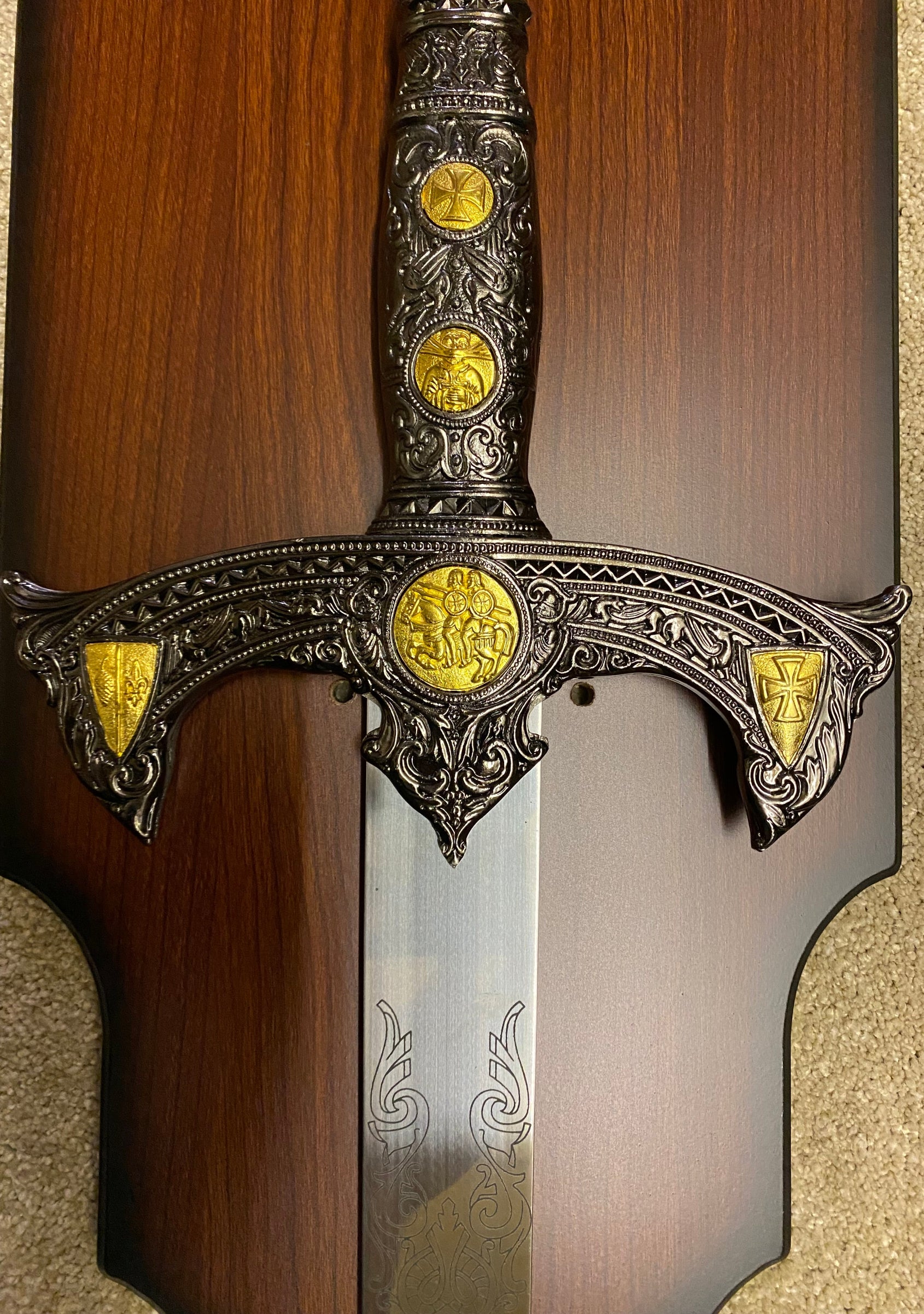Decorative sword with ornate handle and gold embellishments on a wooden background