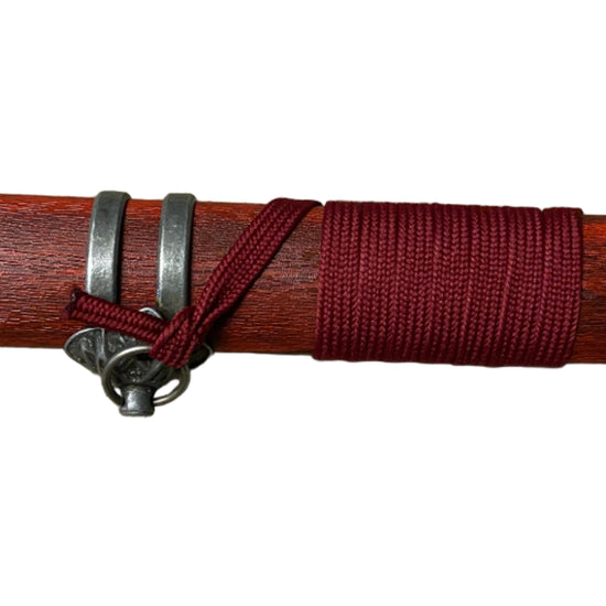 Wooden stick with red band and silver rings on a white background