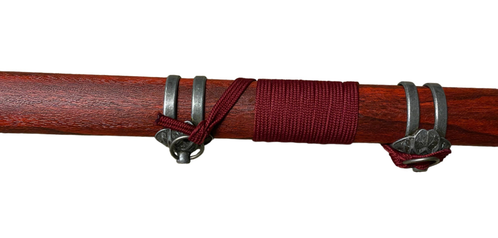 Wooden stick with red band and silver rings on a white background