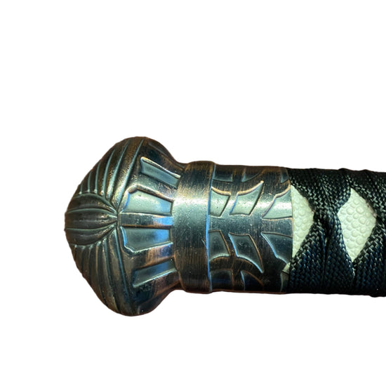 Decorative handle with metallic and black design on a white background