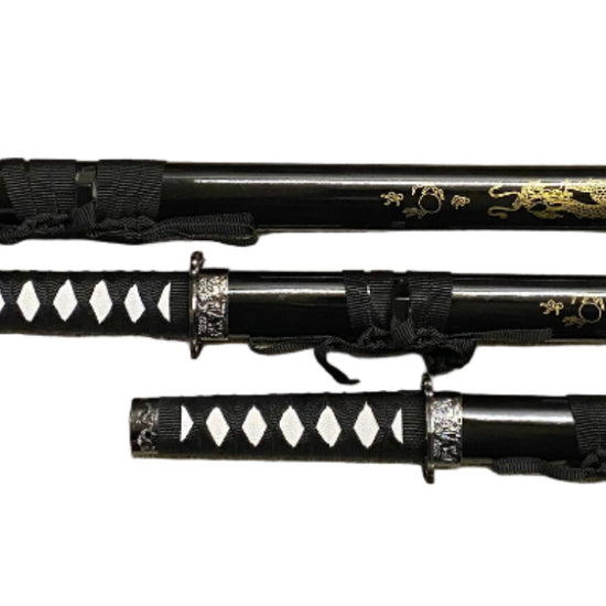 Set of three black and gold samurai swords with sheaths on a white background