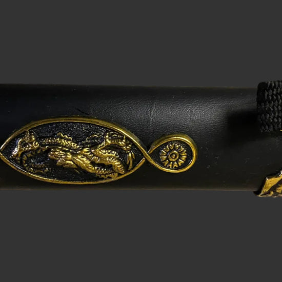 Decorative black object with gold embossed designs on a black background