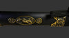 Decorative black object with gold embossed designs on a black background