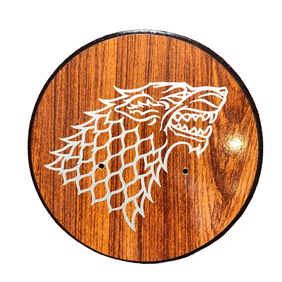 Wooden circular plaque with a white wolf design on a white background