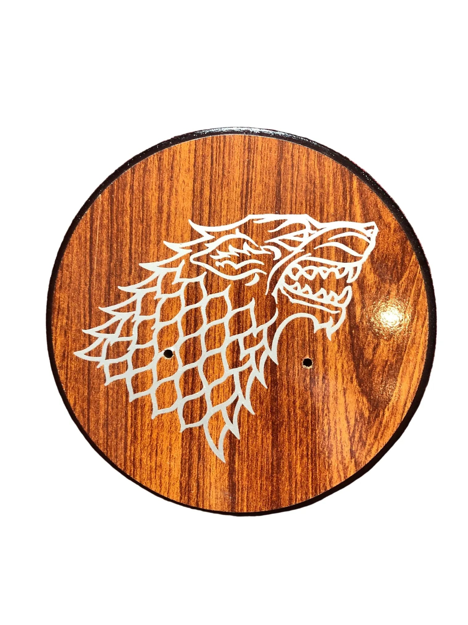 Wooden circular plaque with a white wolf design on a white background