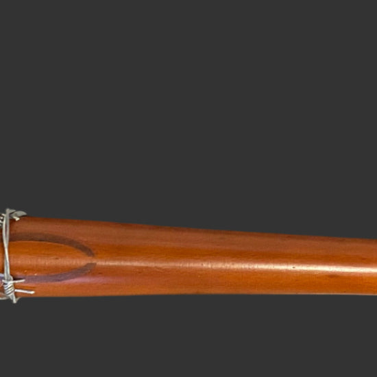 Wooden baseball bat with metal wrap on a black background