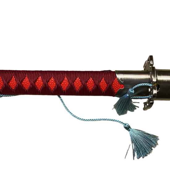 Sword with red handle and blue tassels on a white background
