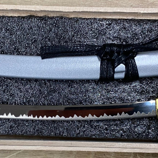 One sword in a wooden box on a wooden surface
