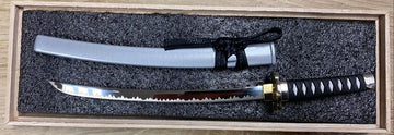 One sword in a wooden box on a wooden surface