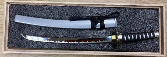 One sword in a wooden box on a wooden surface