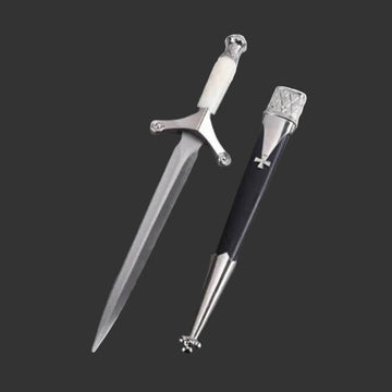 Decorative sword pen on a gray surface with a magazine underneath