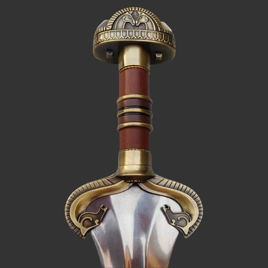 Decorative sword hilt with intricate designs on a white background