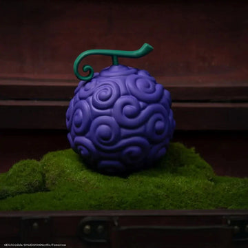 Purple textured object with a green handle on a grassy surface