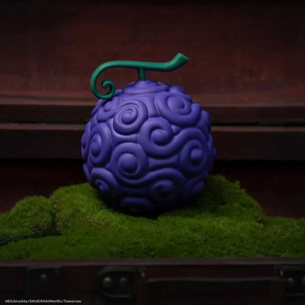 Purple textured object with a green handle on a grassy surface
