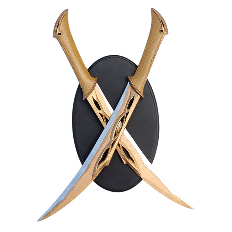 Two replica swords with bronze-colored handles and stainless steel blades, crossed in an X-shape on a black circular plaque, with the handles resting on top of the plaque.