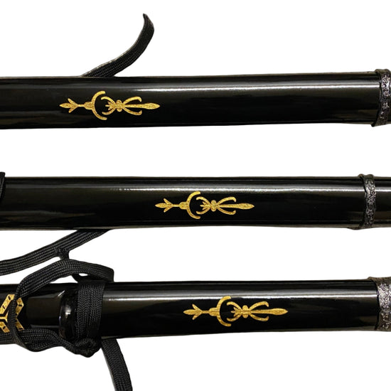 Three black sword handles with gold decorative symbols on a gray background