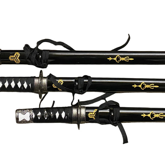 Three black samurai swords with gold accents on a gray background
