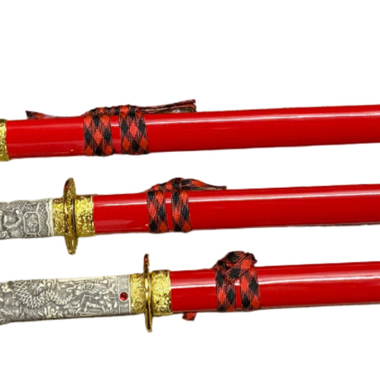 Three red swords with silver and gold handles on a white background
