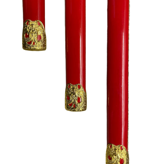 Three red objects with gold decorative elements on a white background