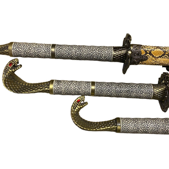 Three ornate swords with decorative sheaths on a white background
