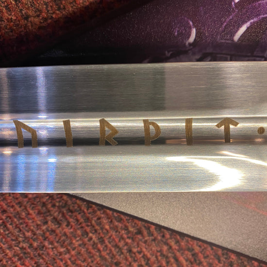 Metallic object with engraved text on a textured surface