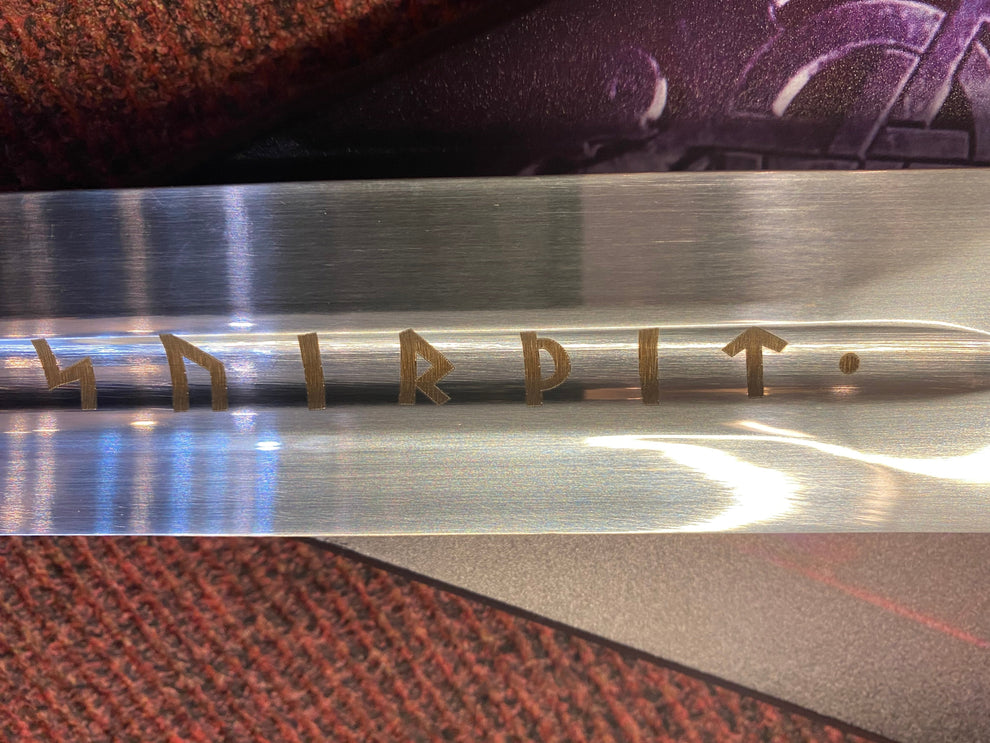Metallic object with engraved text on a textured surface