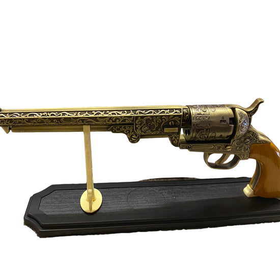 Decorative revolver on a stand with a white background