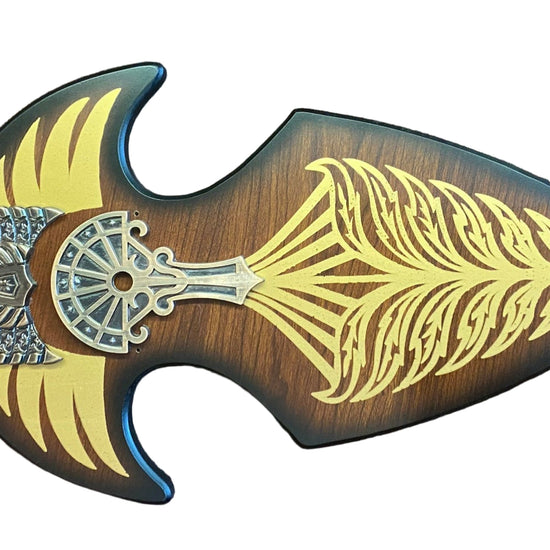 Decorative weapon with gold and silver designs on a brown textured background