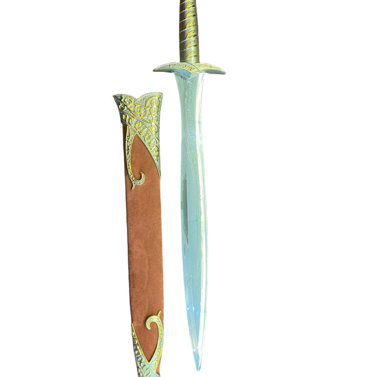Decorative dagger with ornate handle on a brown textured surface