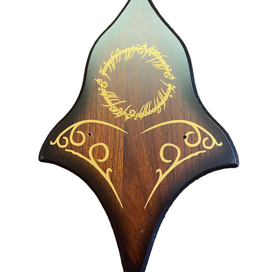 Wooden guitar pickguard with engraved text on a brown textured surface