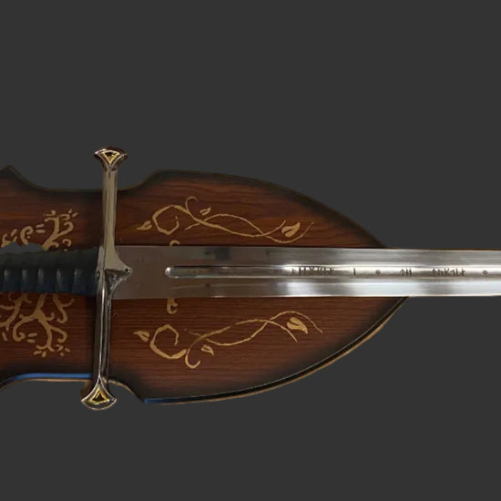 A decorative medieval-style sword with a dark brown wooden scabbard featuring gold floral engravings, a silver blade, and a gold crossguard, shown against a solid dark gray background.
