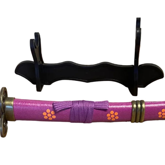 Purple sword with decorative handle on a cardboard surface